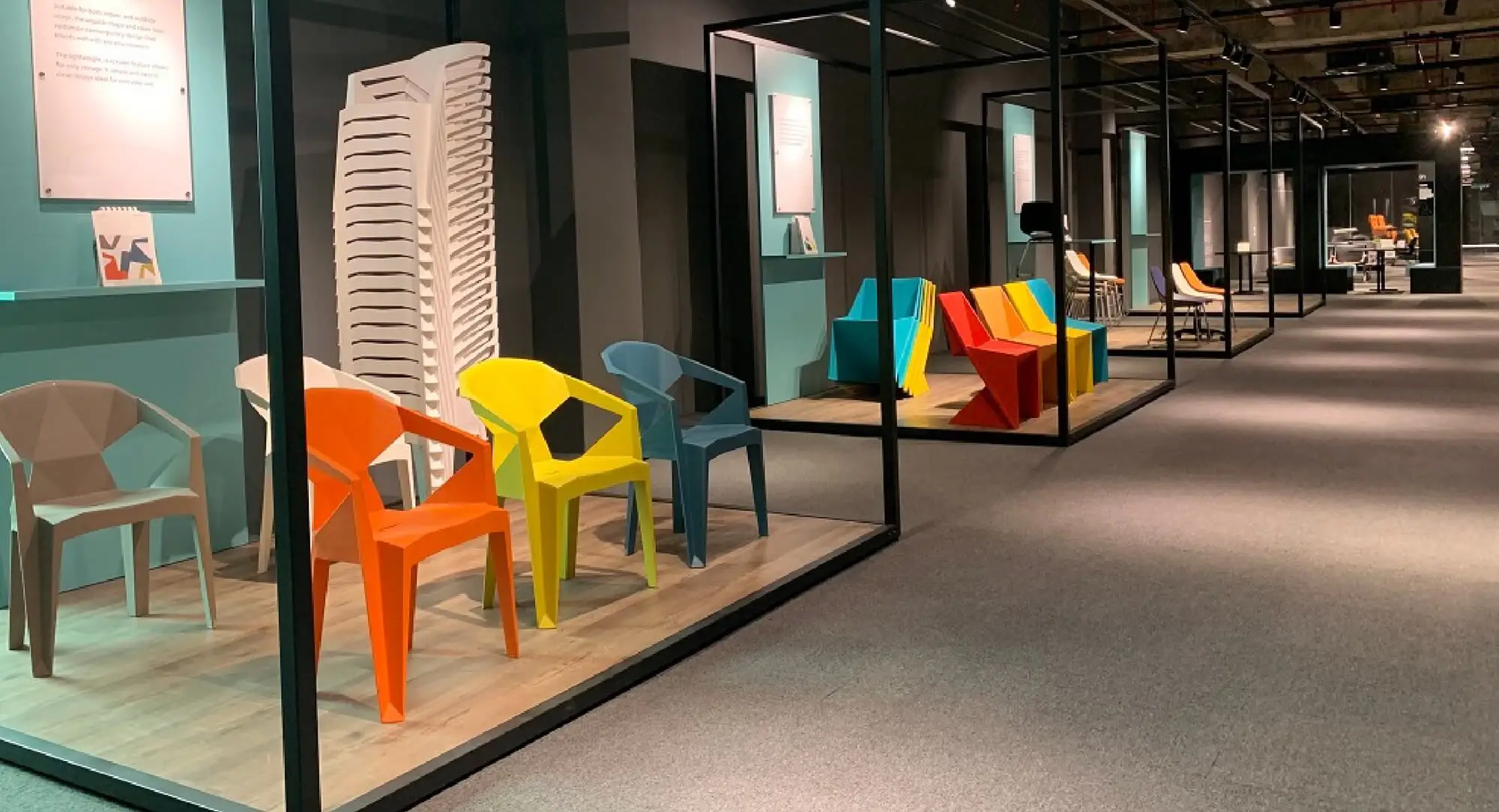Moulded polymer chairs in orange, yellow and blue, with a tall stack behind